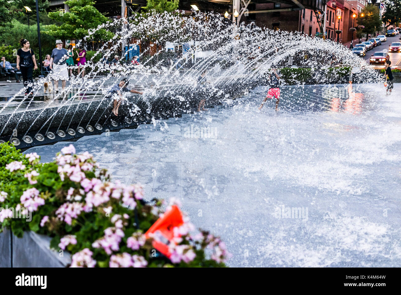 Washington DC, USA - 4 août 2017 : de jeunes enfants jouant dans l'eau Fontaine à Georgetown park en soirée avec les éclaboussures d'eau Banque D'Images