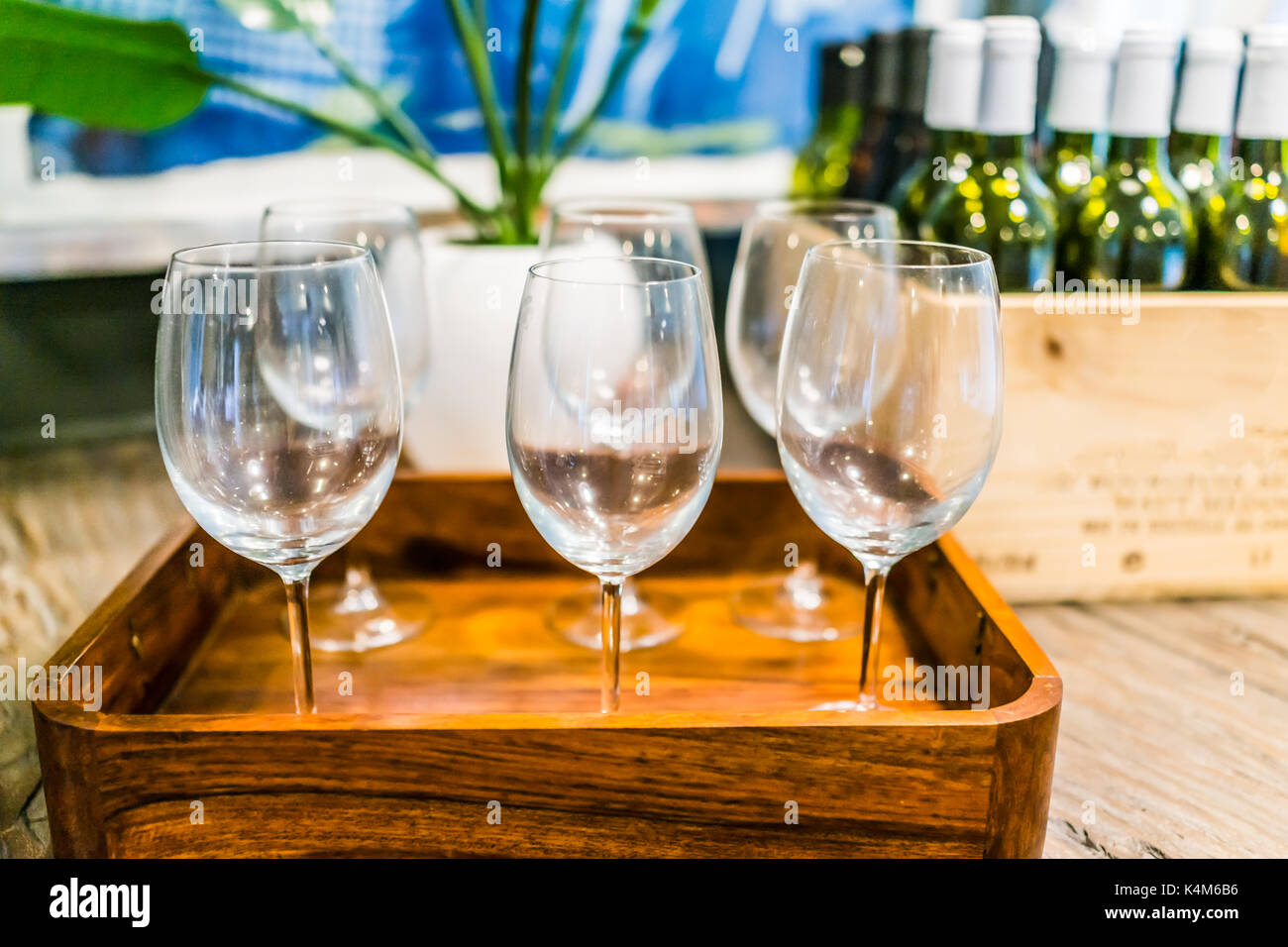 Gros plan du vide des verres à vin sur plateau avec des caisses en bois de bouteilles sur la table dans la chambre Banque D'Images