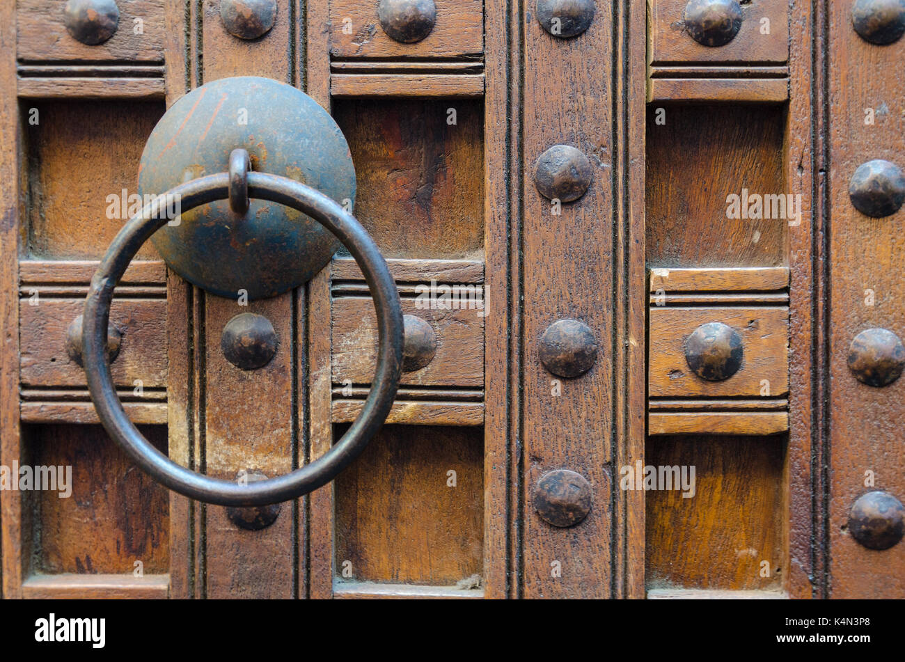 Une poignée de porte, une porte en bois clouté. Banque D'Images