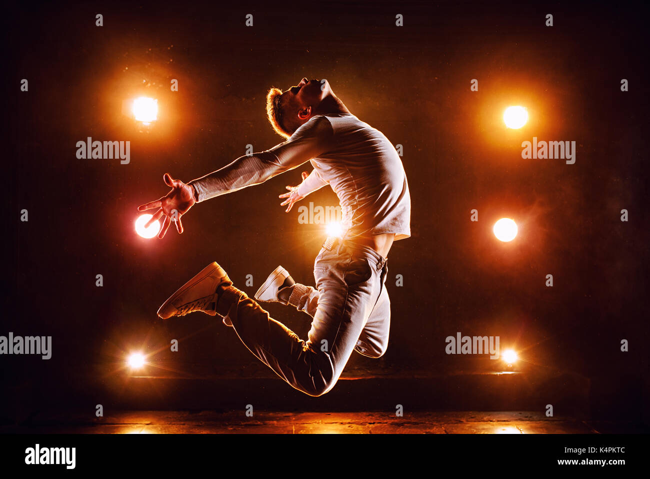 Jeune homme break dancer jumping haut dans l'étape club avec des lumières Banque D'Images