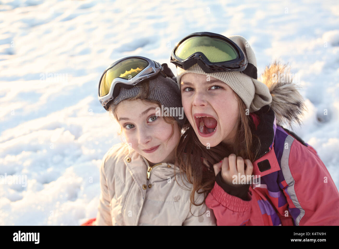 Happy friends s'amuser sur la neige Banque D'Images