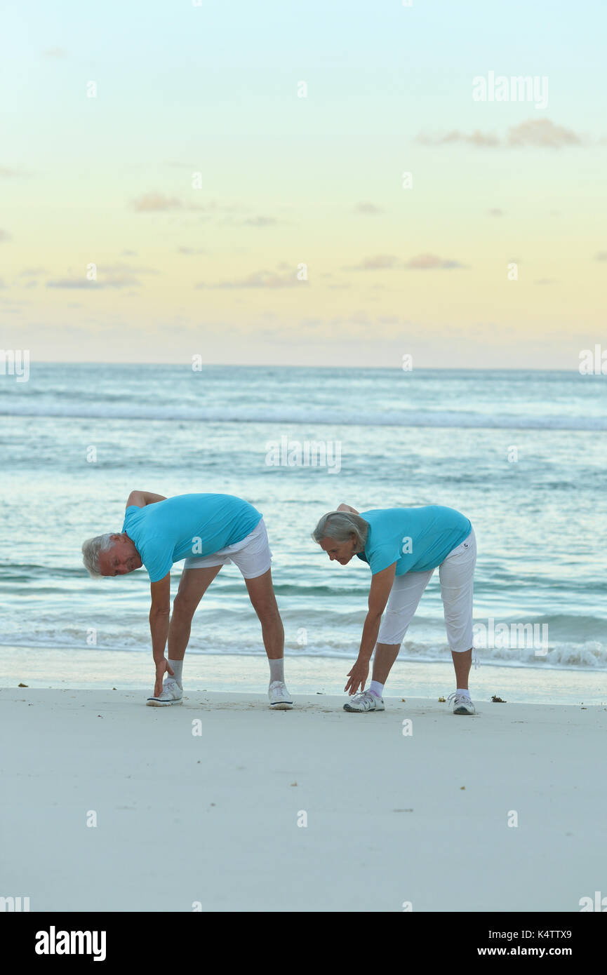 Couple exercices sur la plage de sable de soir Banque D'Images