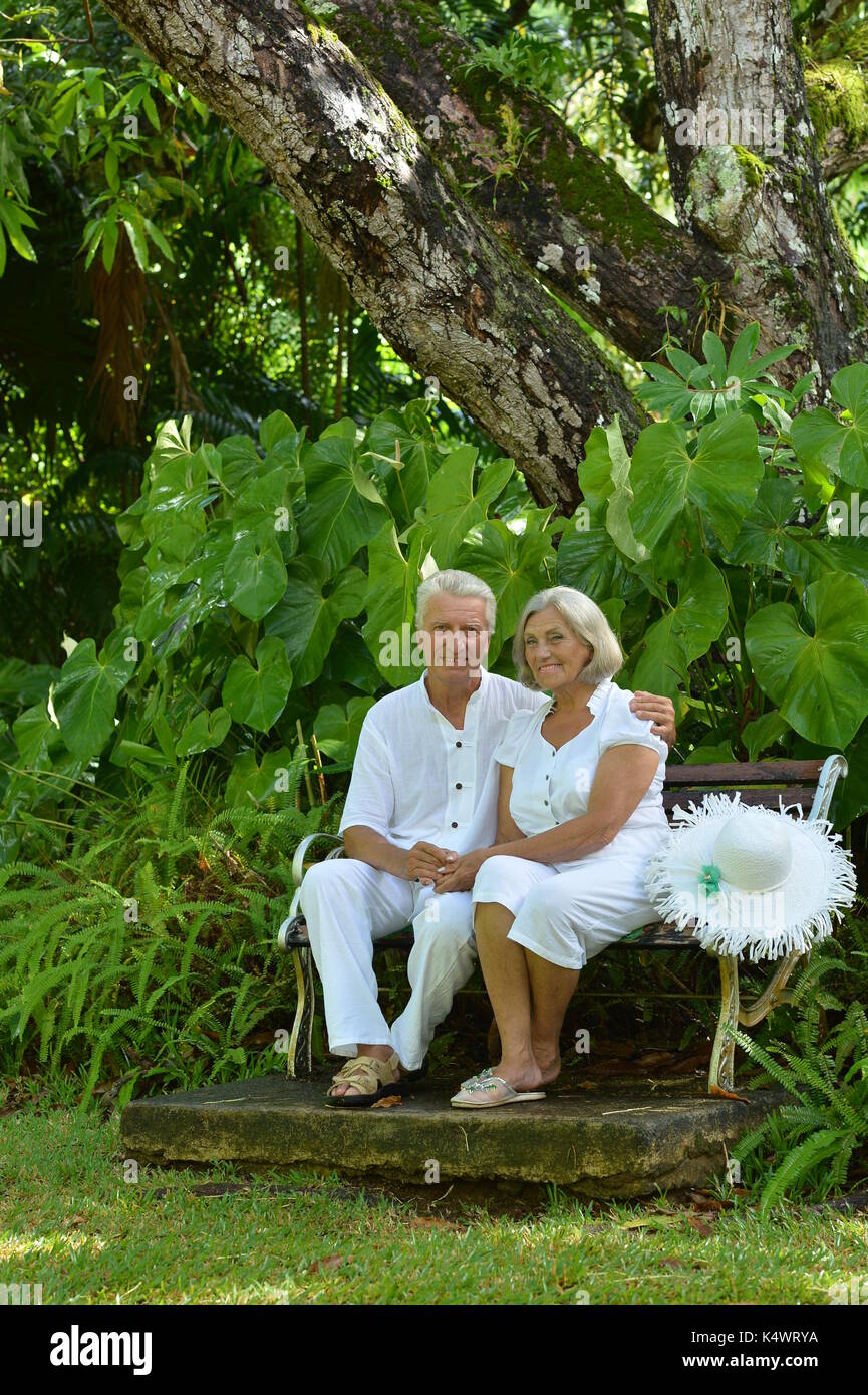 Happy senior couple sitting at banc en bois à resort Banque D'Images