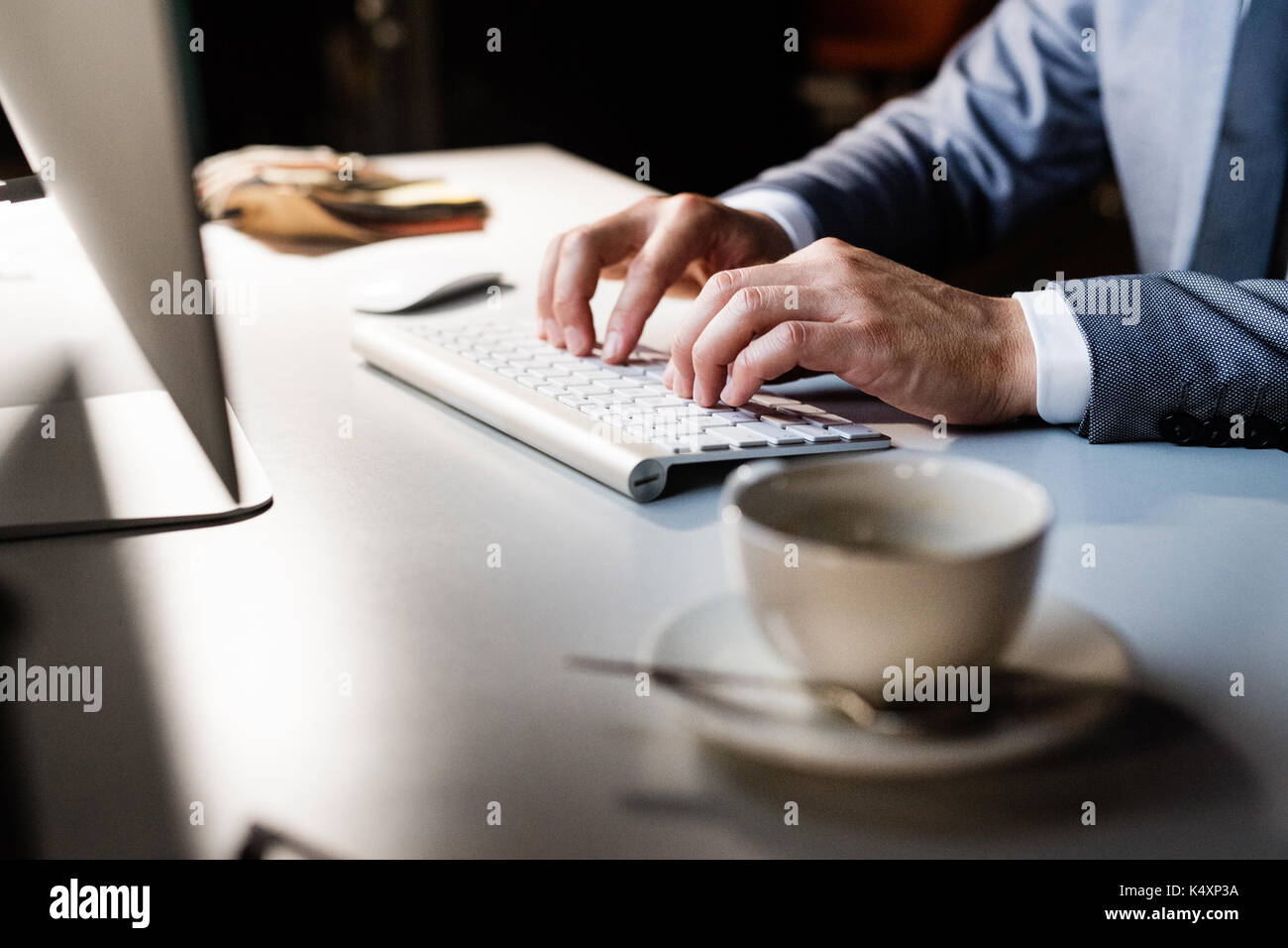 Les mains sur le clavier. businessman dans son bureau pendant la nuit. Banque D'Images