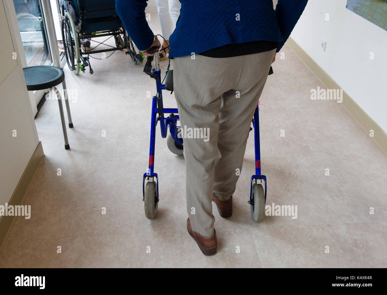 Un homme âgé à marcher derrière son déambulateur Banque D'Images