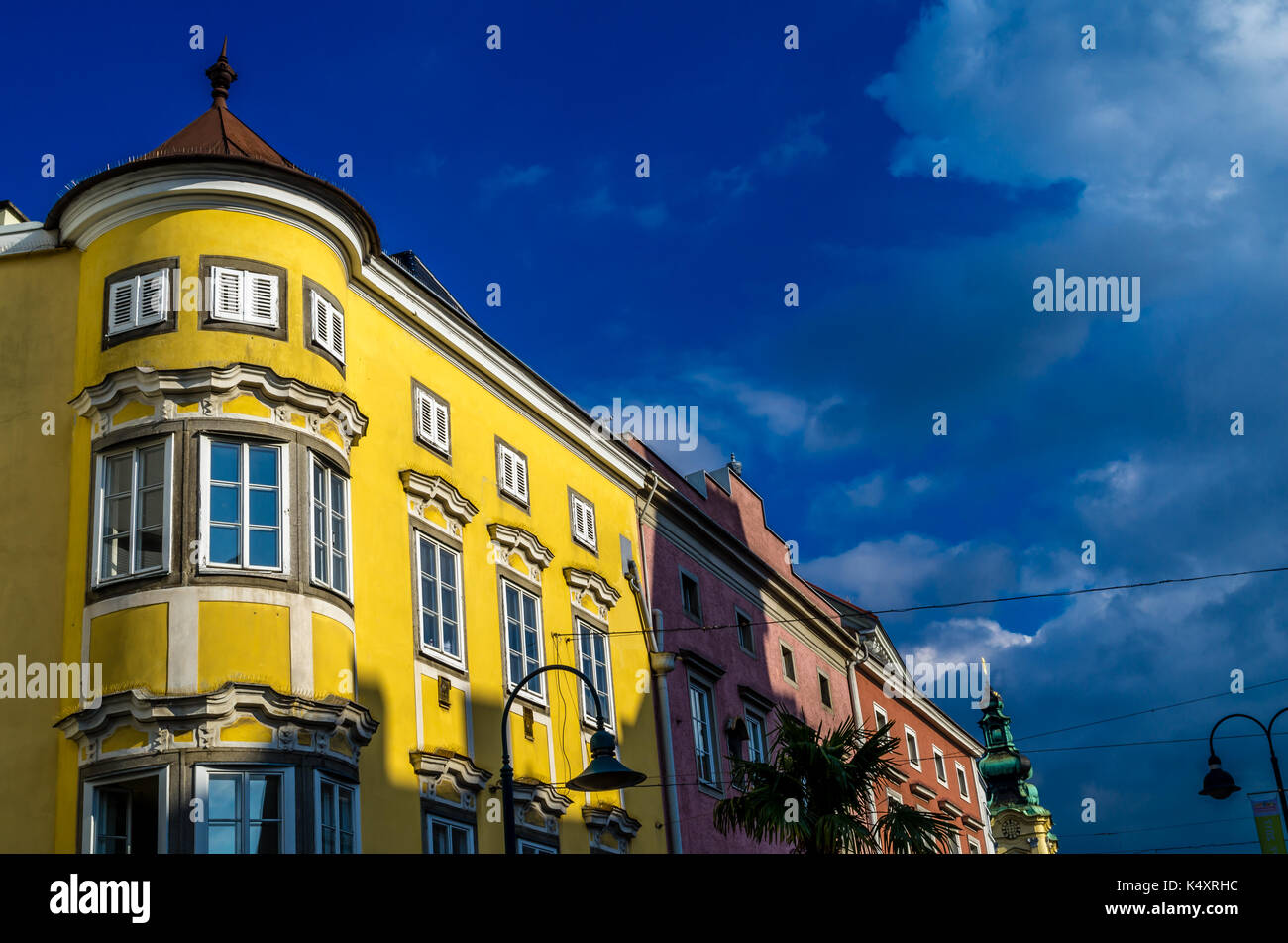 Façade extérieure des bâtiments de couleur jaune à Linz, Autriche sur une journée ensoleillée avec un ciel bleu. Banque D'Images