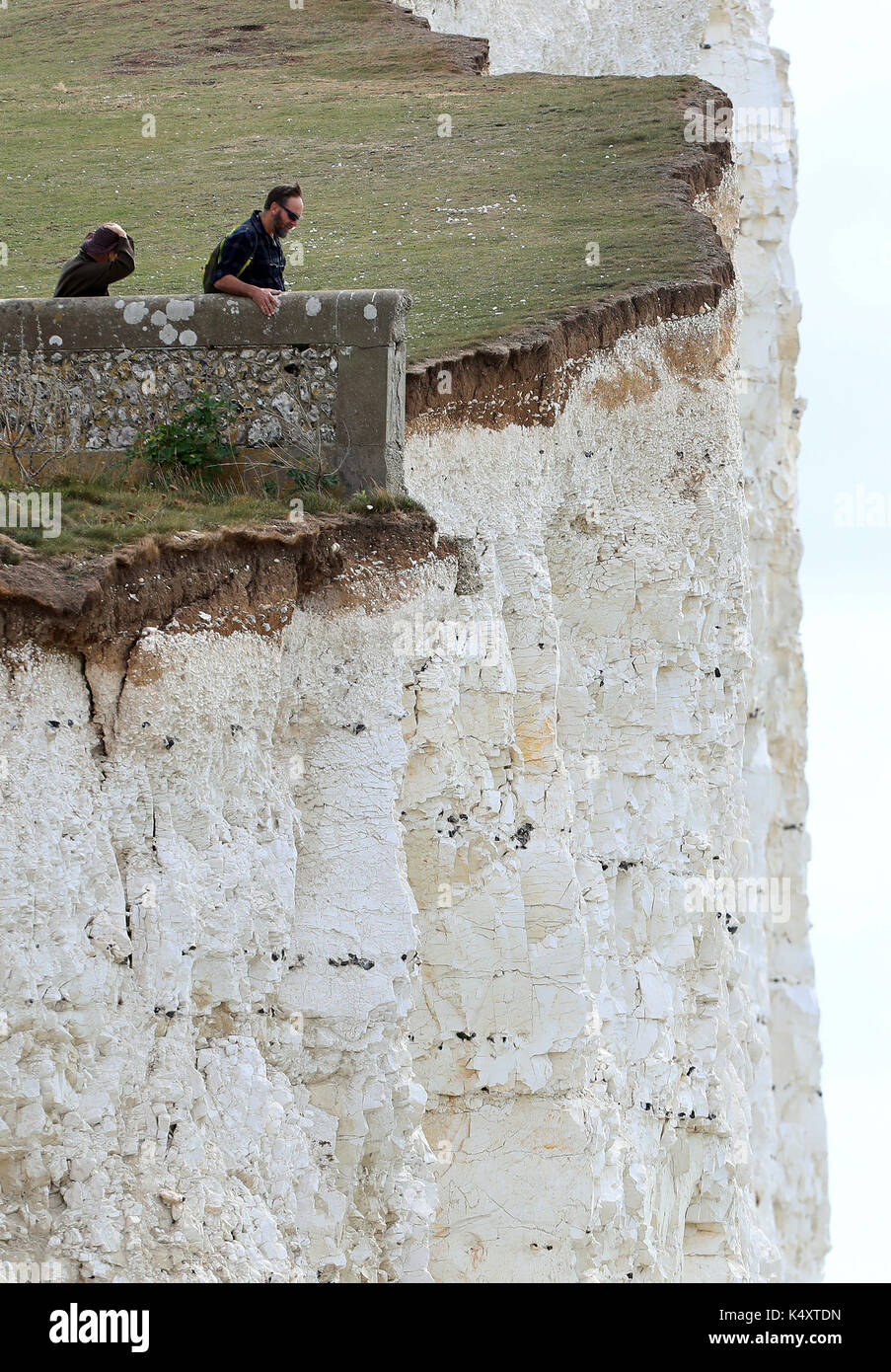 Un couple se tenir sur le bord de la falaise à Urrugne dans l'East Sussex en dépit des avertissements de sécurité suite aux récentes chutes de pierres dans la région. photo date : Jeudi 7 septembre 2017. crédit photo doit se lire : gareth fuller/pa wire Banque D'Images