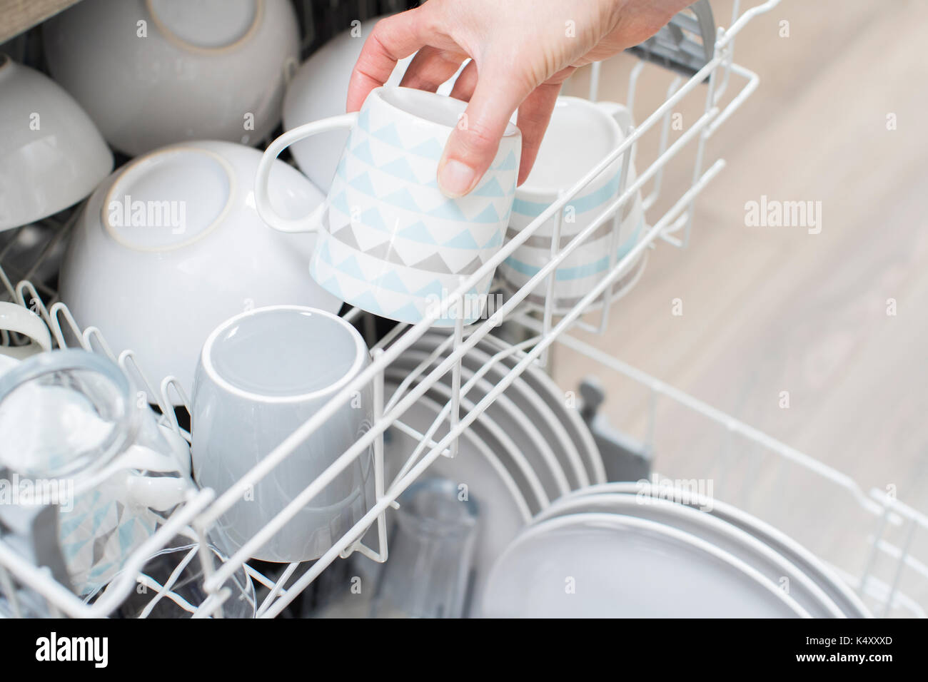 Close up of woman chargement de la vaisselle dans un lave-vaisselle Banque D'Images