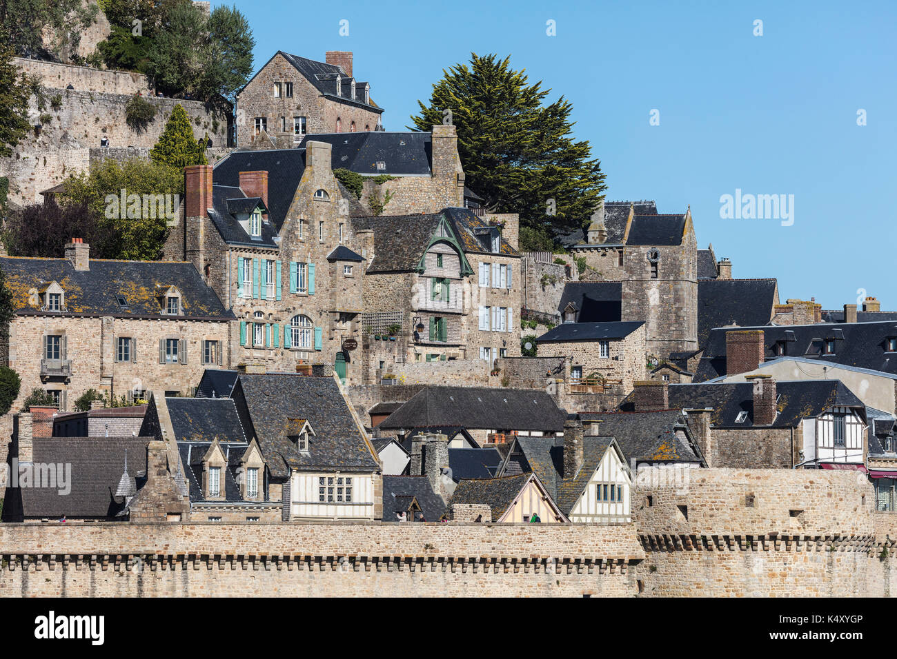 Mont Saint-Michel (Saint Michael's Mount), Normandie, nord-ouest de la France : maisons du village et les remparts en avant-plan (pas disponible pour pos Banque D'Images