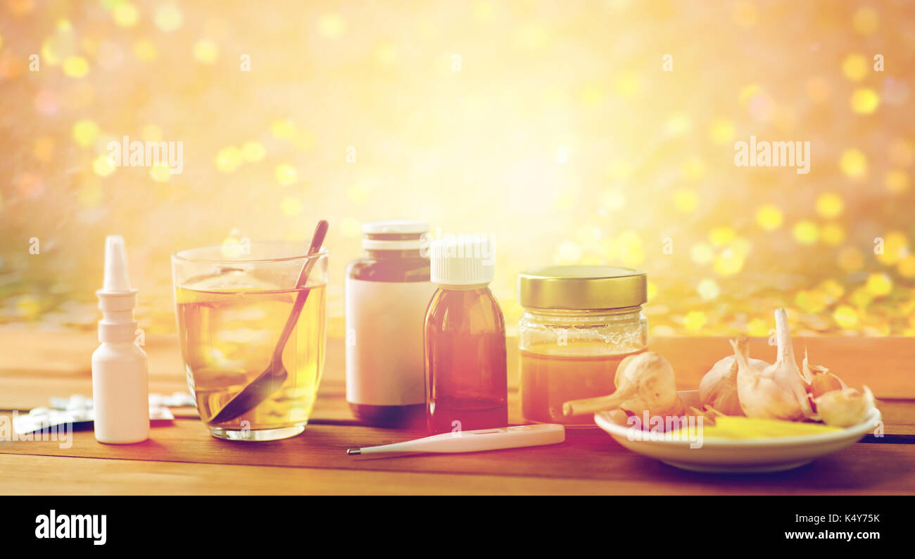 La drogue, thermomètre, le miel et une tasse de thé sur bois Banque D'Images