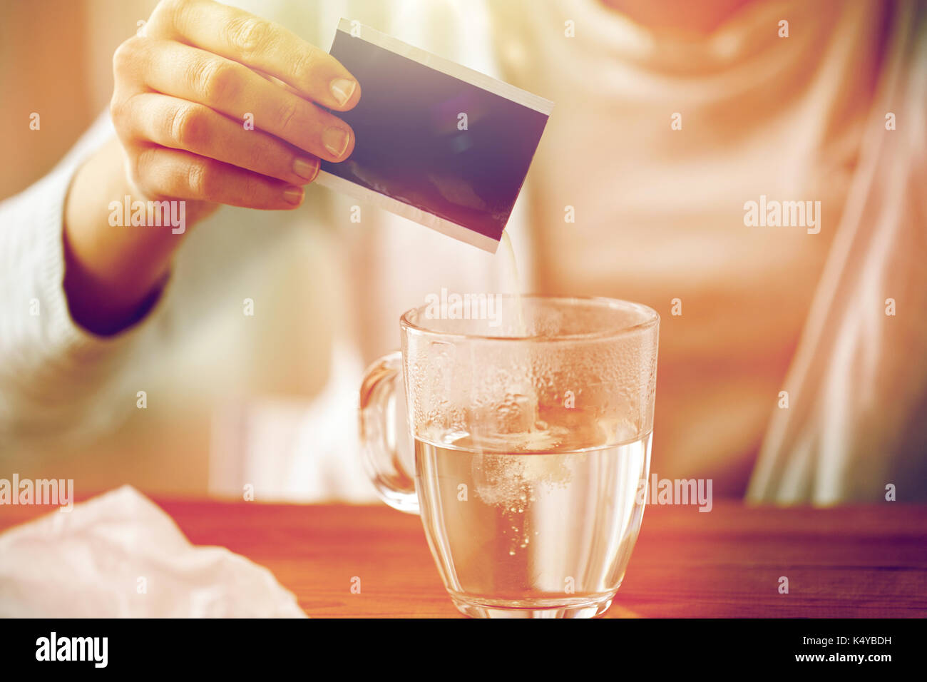 Woman pouring médicament dans tasse de l'eau Banque D'Images