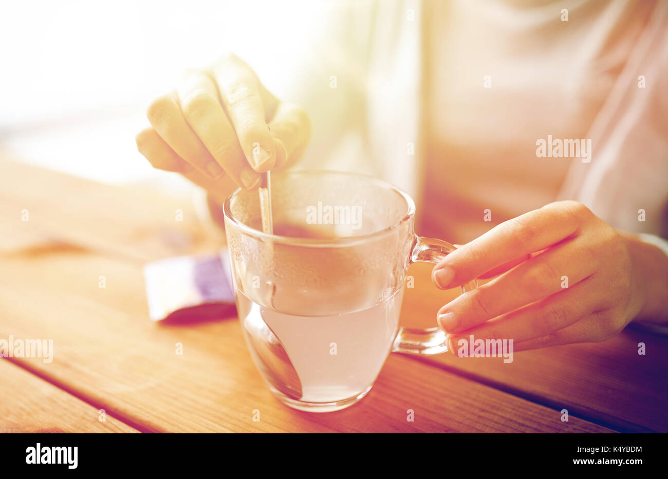 Femme en remuant de médicament en tasse d'eau Banque D'Images