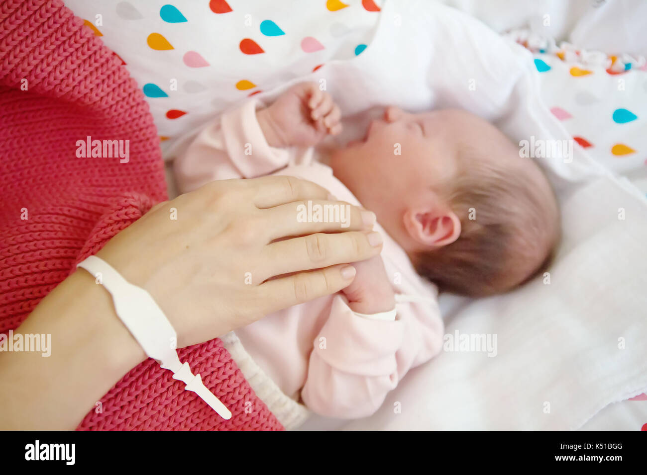 La Main De La Mere Au Nouveau Ne Bebe Fille Femme Caressant Dans Son Berceau Bracelets De Maternite Sur Leurs Mains Pour Aider A Les Identifier Photo Stock Alamy