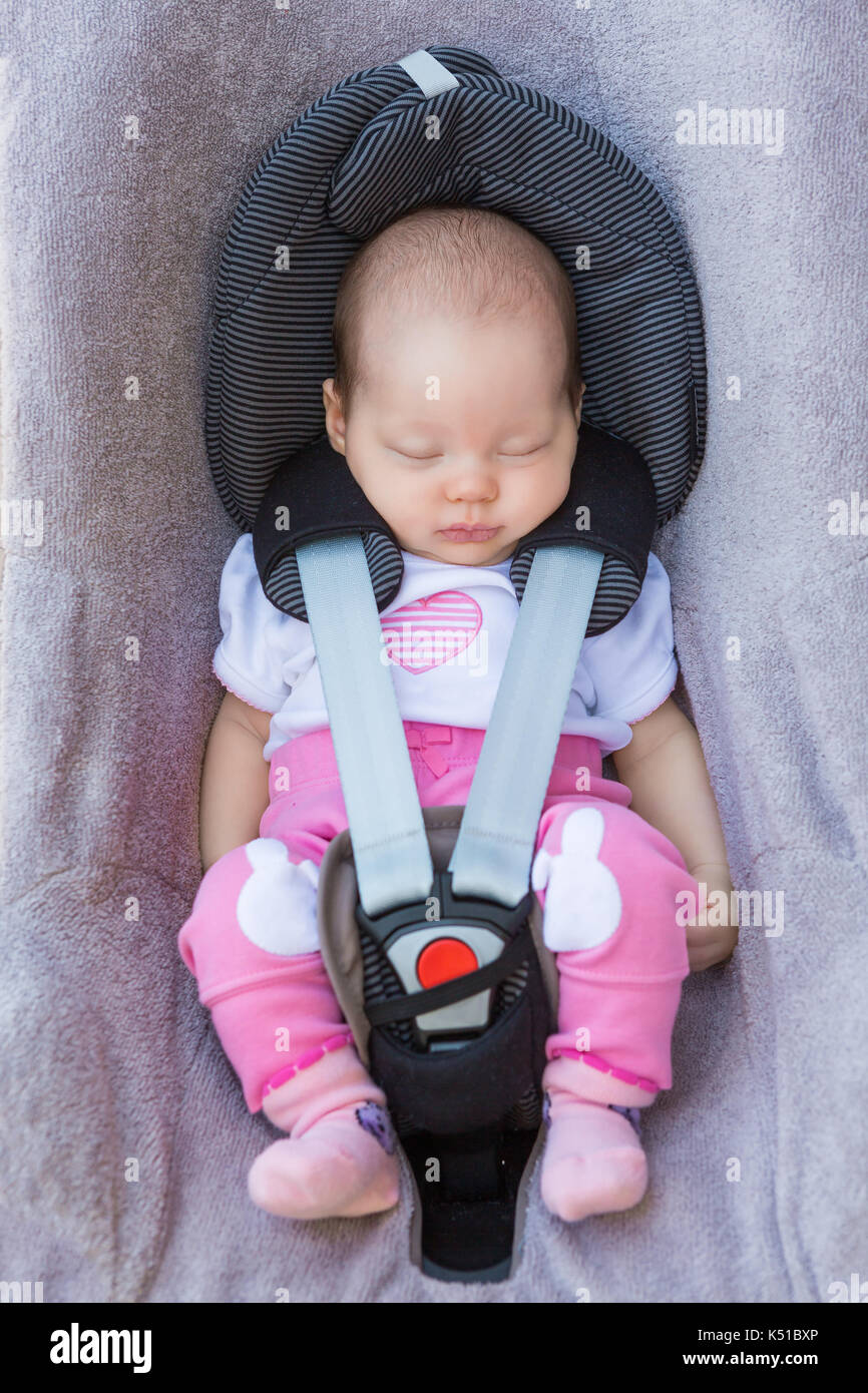 Bébé nouveau-né fille assise dans un siège de voiture avec ceinture de  sécurité la ceinture de sécurité Photo Stock - Alamy
