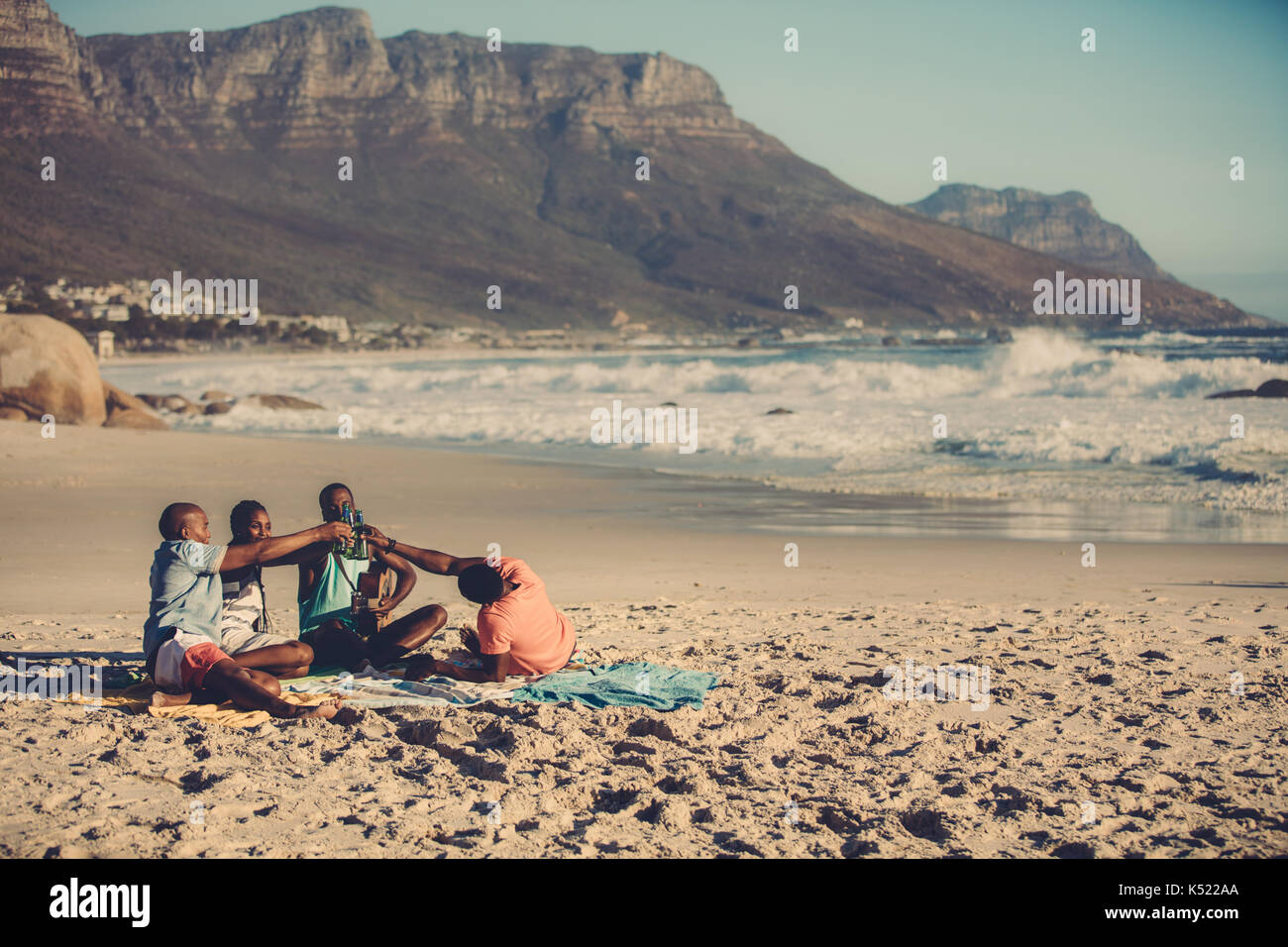 Portrait de groupe d'amis jouer de la guitare et de boire de la bière. Les gens sur la plage ayant une partie. Banque D'Images