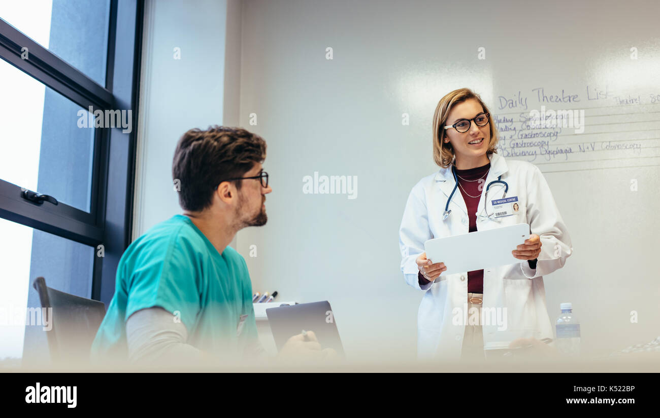 Femme médecin menant à l'hôpital de la réunion. Son équipe d'information professionnels de la médecine dans la salle de réunion. Banque D'Images