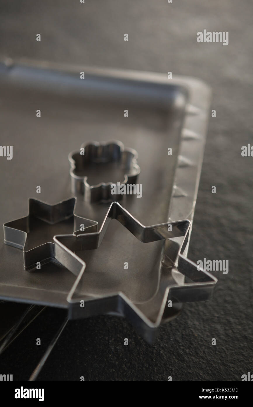Close up of pastry cutter et plaque de cuisson sur grille de refroidissement à table Banque D'Images