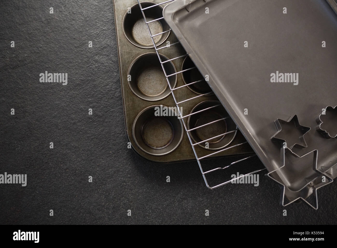 Vue de dessus de divers coupe-pâte et plaque avec grille de refroidissement sur l'étain muffin à table Banque D'Images