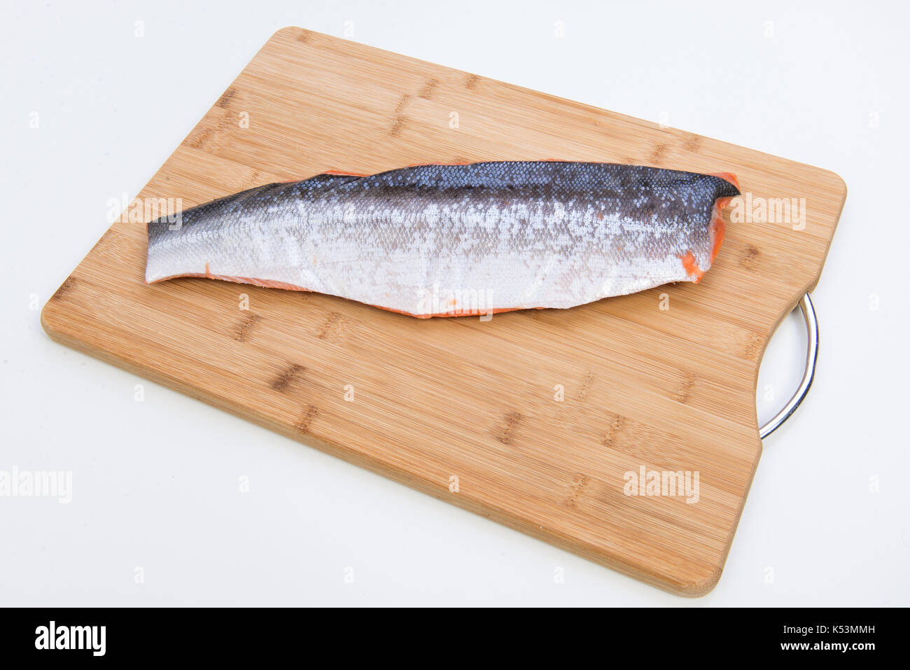 Filet de poisson saumon congelé isolé sur conseil du bois. Banque D'Images