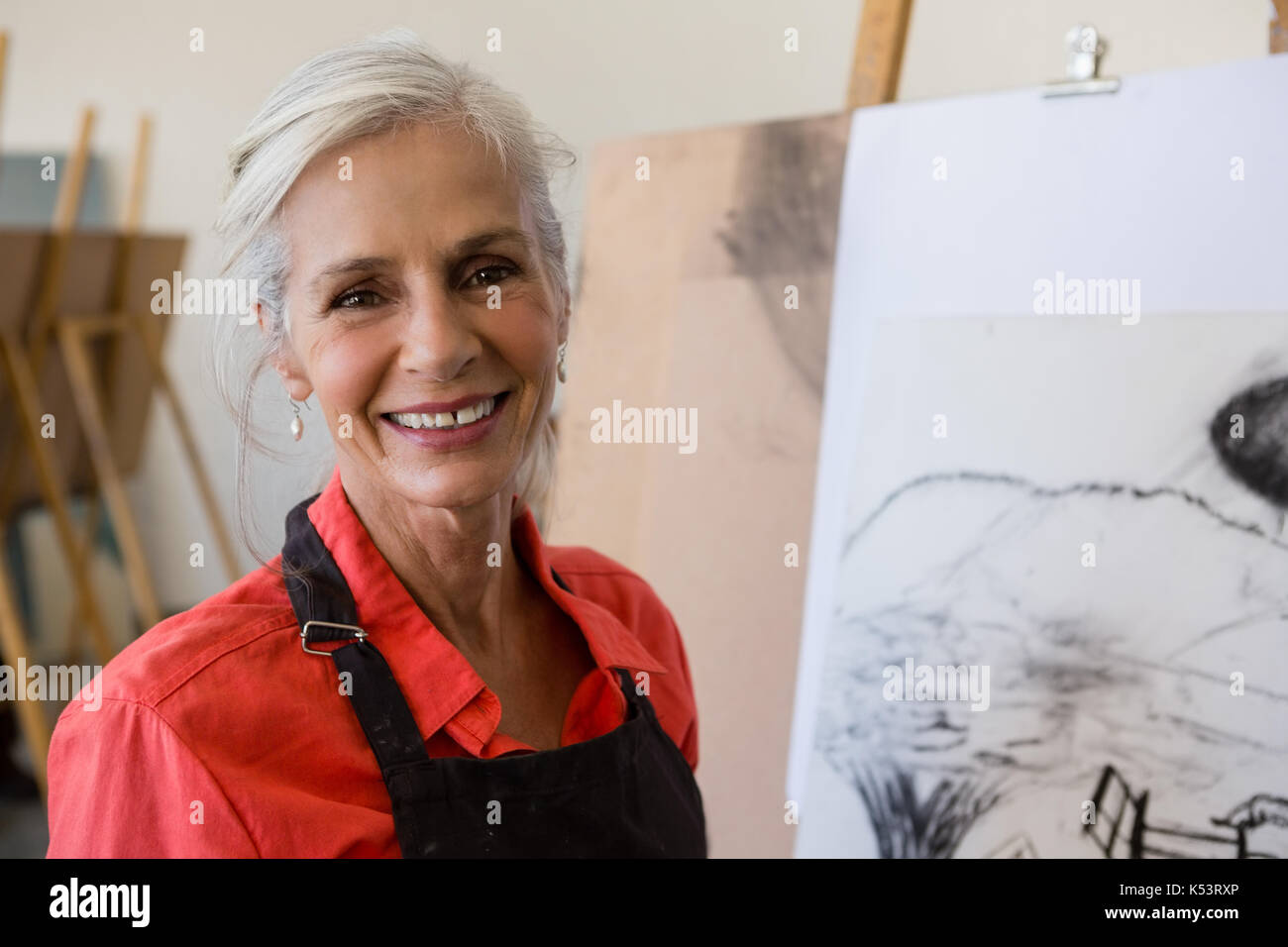 Close up portrait of smiling woman standing by painting Banque D'Images