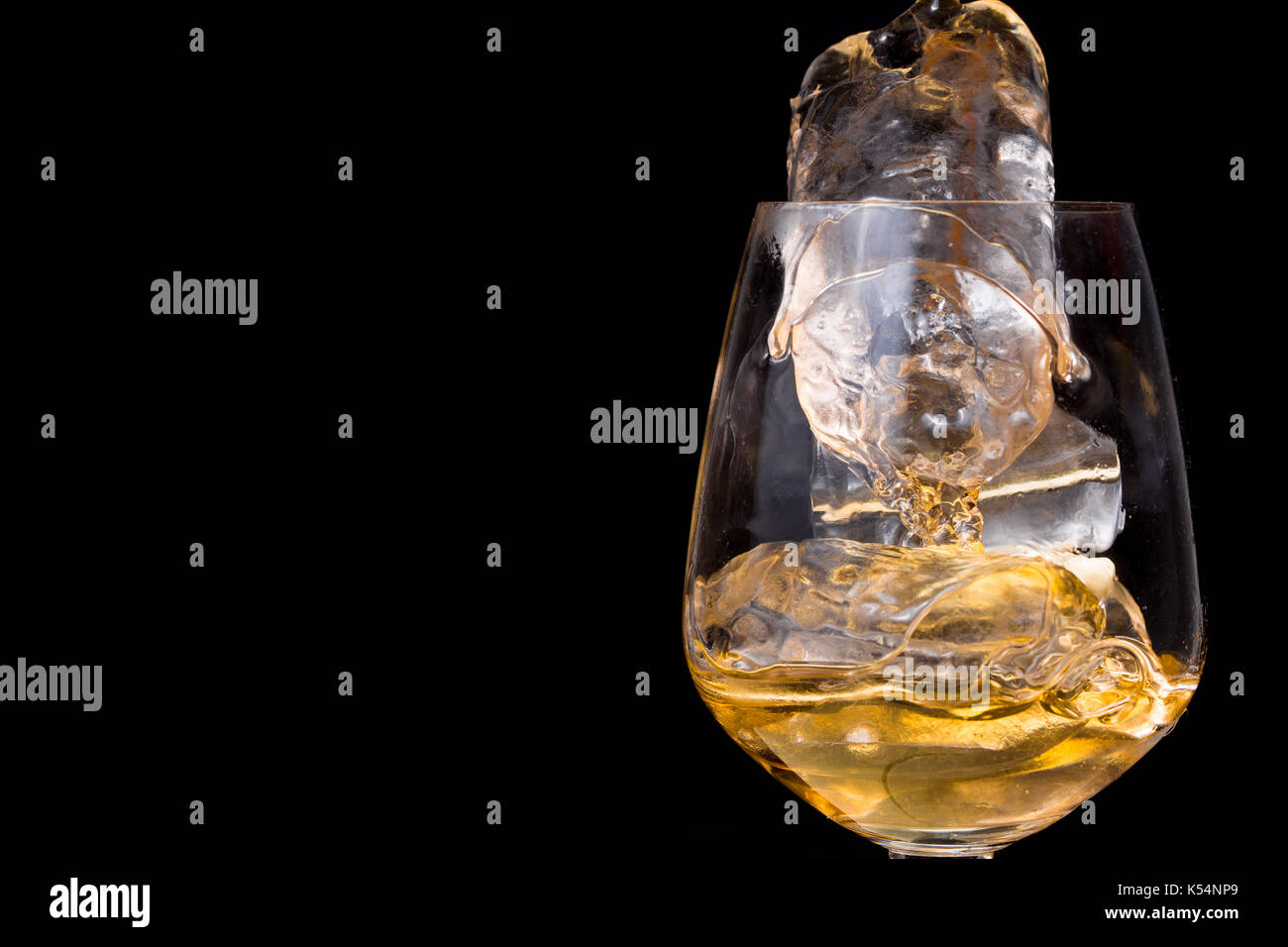 Verre de whisky avec de la glace sur fond noir. Banque D'Images