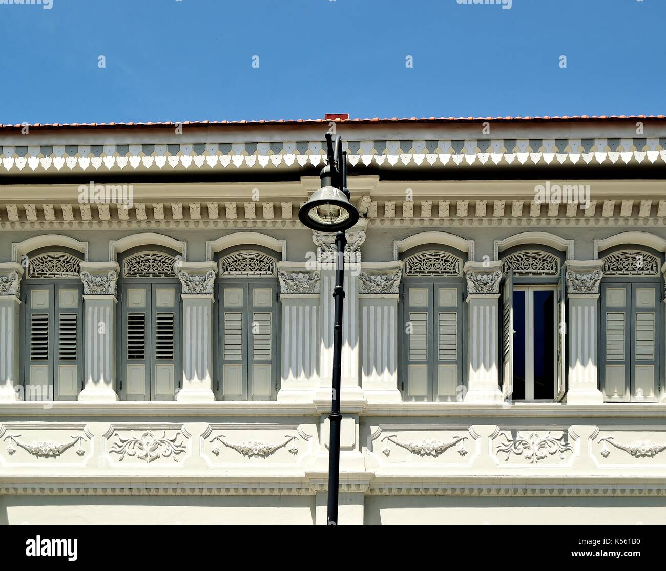 Boutique traditionnelle en bois gris extérieur de maison avec les majorquines, fenêtres en forme de colonnes et de sculptures ornées dans le district de Joo Chiat singapore Banque D'Images