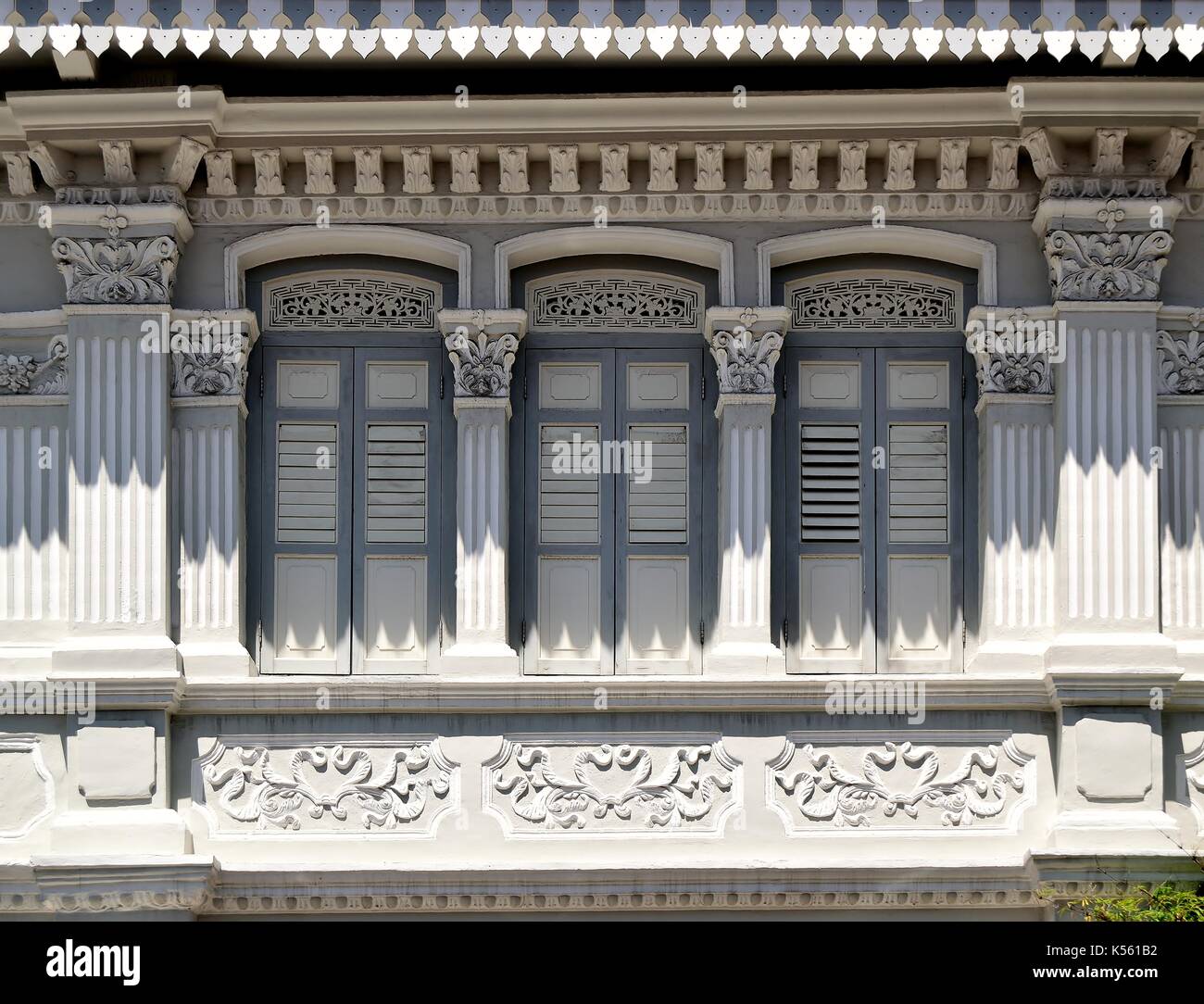 Boutique traditionnelle en bois gris extérieur de maison avec les majorquines, fenêtres en forme de colonnes et de sculptures ornées dans le district de Joo Chiat singapore Banque D'Images