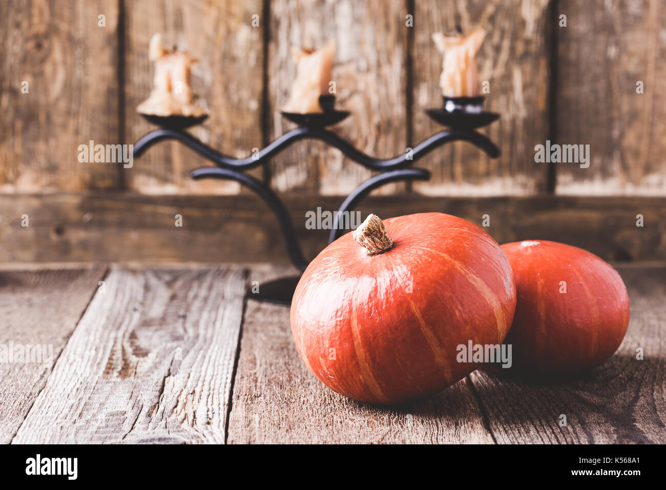 Décorations accueil chaleureux de l'automne. Nature morte avec les citrouilles et les bougies sur fond rustique en bois Banque D'Images