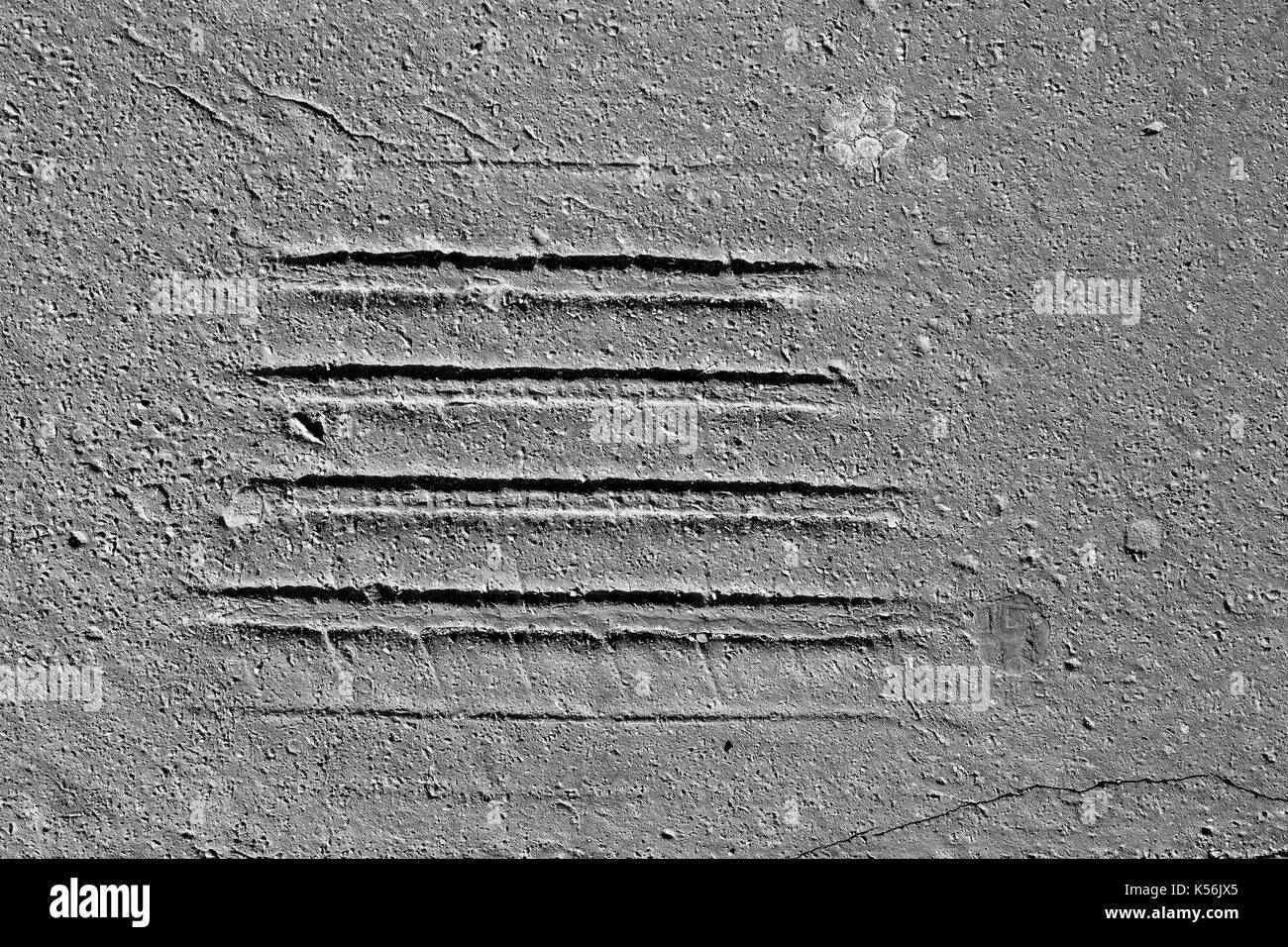 Les empreintes de pneus sur la vieille route d'asphalte fissuré dans blak et blanc Banque D'Images