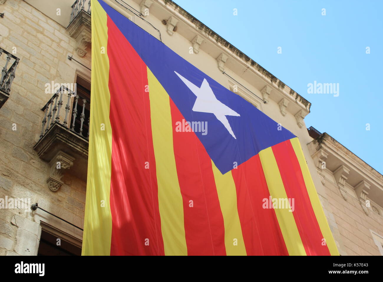 Un grand drapeau de l'indépendance de la Catalogne est suspendu un vieux bâtiment à Gérone, Espagne. Banque D'Images