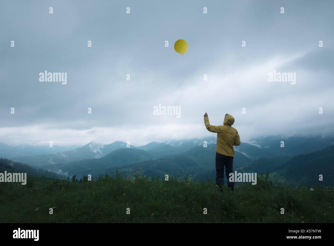 Homme avec ballon jaune en haute montagne Banque D'Images