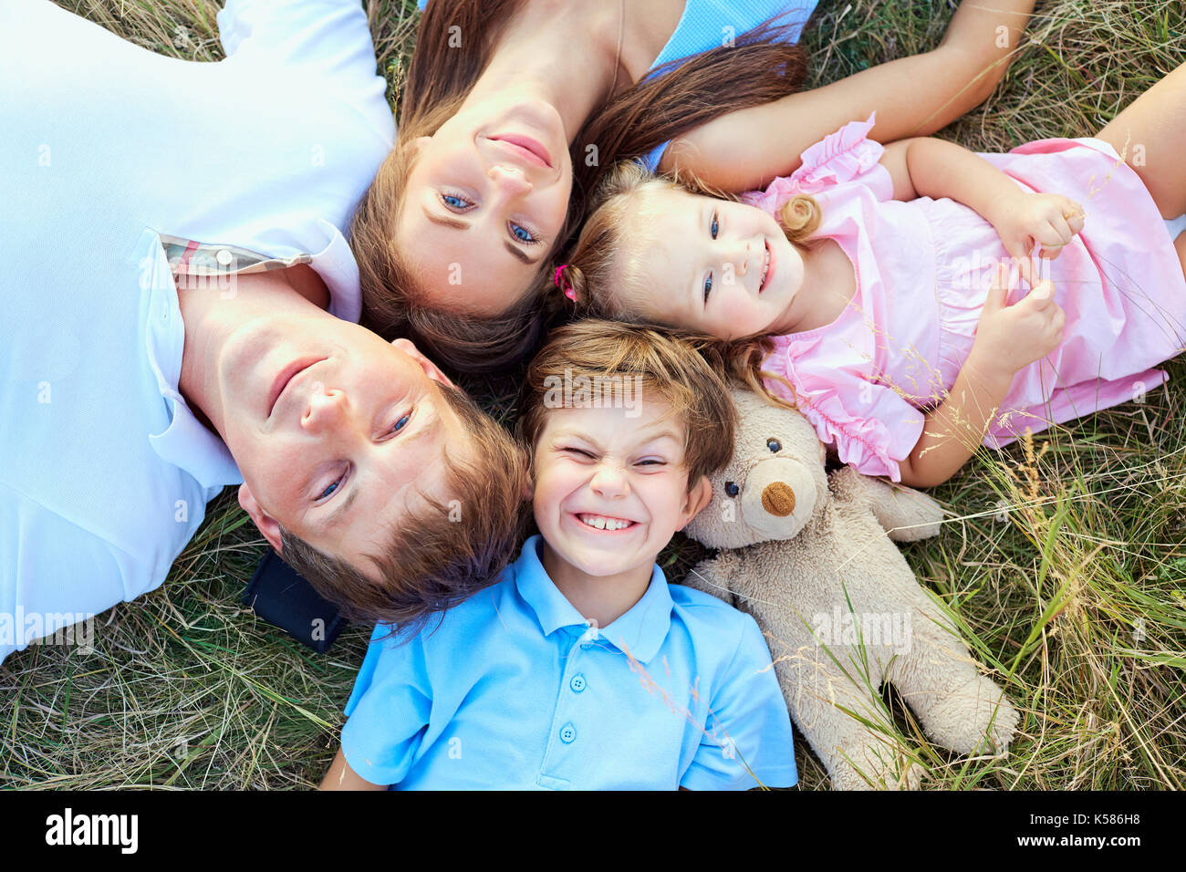 Happy Family lying on grass close-up Vue de dessus. Banque D'Images