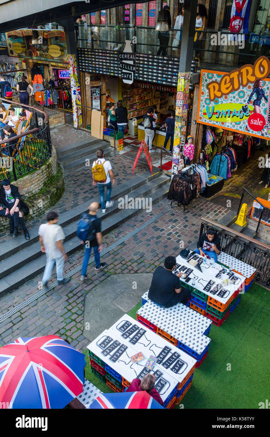 Les gens s'asseoir à l'extérieur le tueur en série Cafe à Camden Town, Londres à des tables et sur des bancs faits de plastique caillebotis. Banque D'Images