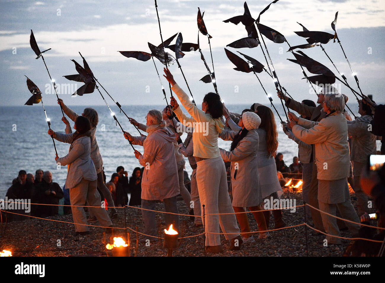 'Un' éphémère performance sur la plage en face de la jetée ouest émulant un murmuration d'étourneaux pour marquer la finale de l'Brighton Festival 2015 cr. Banque D'Images