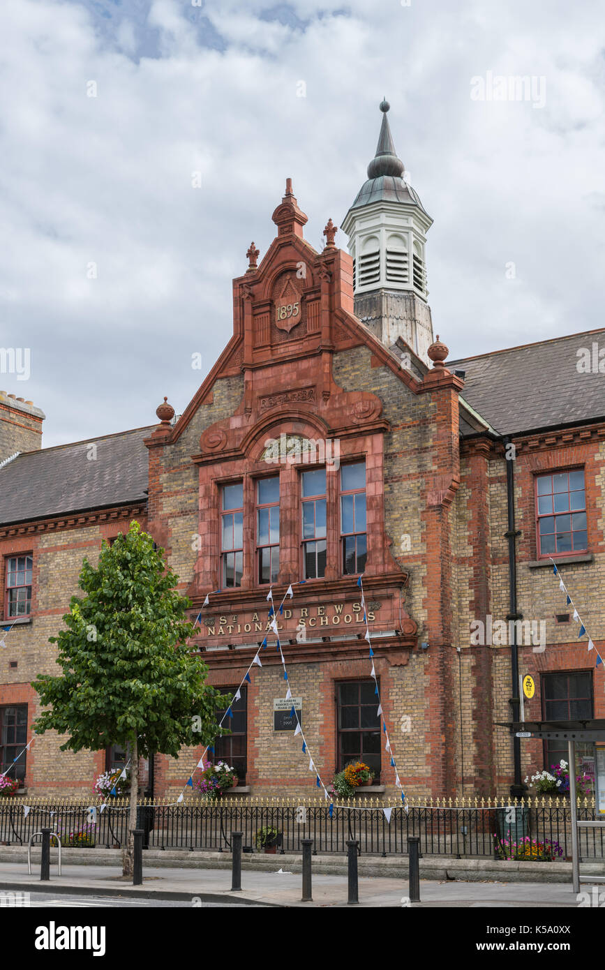 Dublin, Irlande - août 7, 2017 : la brique et pierres rouges façade du quartier historique de St Andrews écoles nationales sur pearce street est décoré de guirlande drapeau Banque D'Images