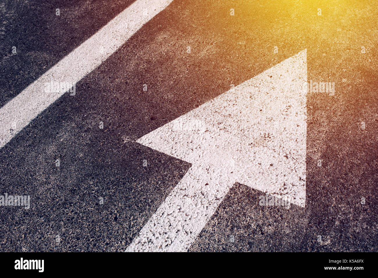 Déménagement dans la bonne direction, flèche blanche symbole comme signe de la circulation sur route asphaltée pour motion donnant vers le succès de l'avenir représenté par le Banque D'Images