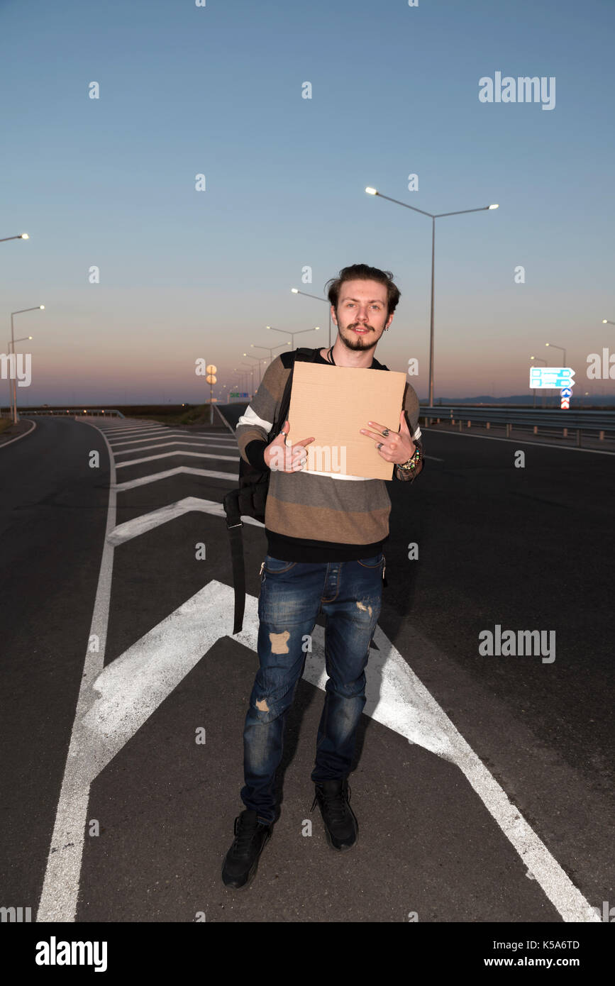 21 ans bel homme l'auto-stop sur la route Banque D'Images