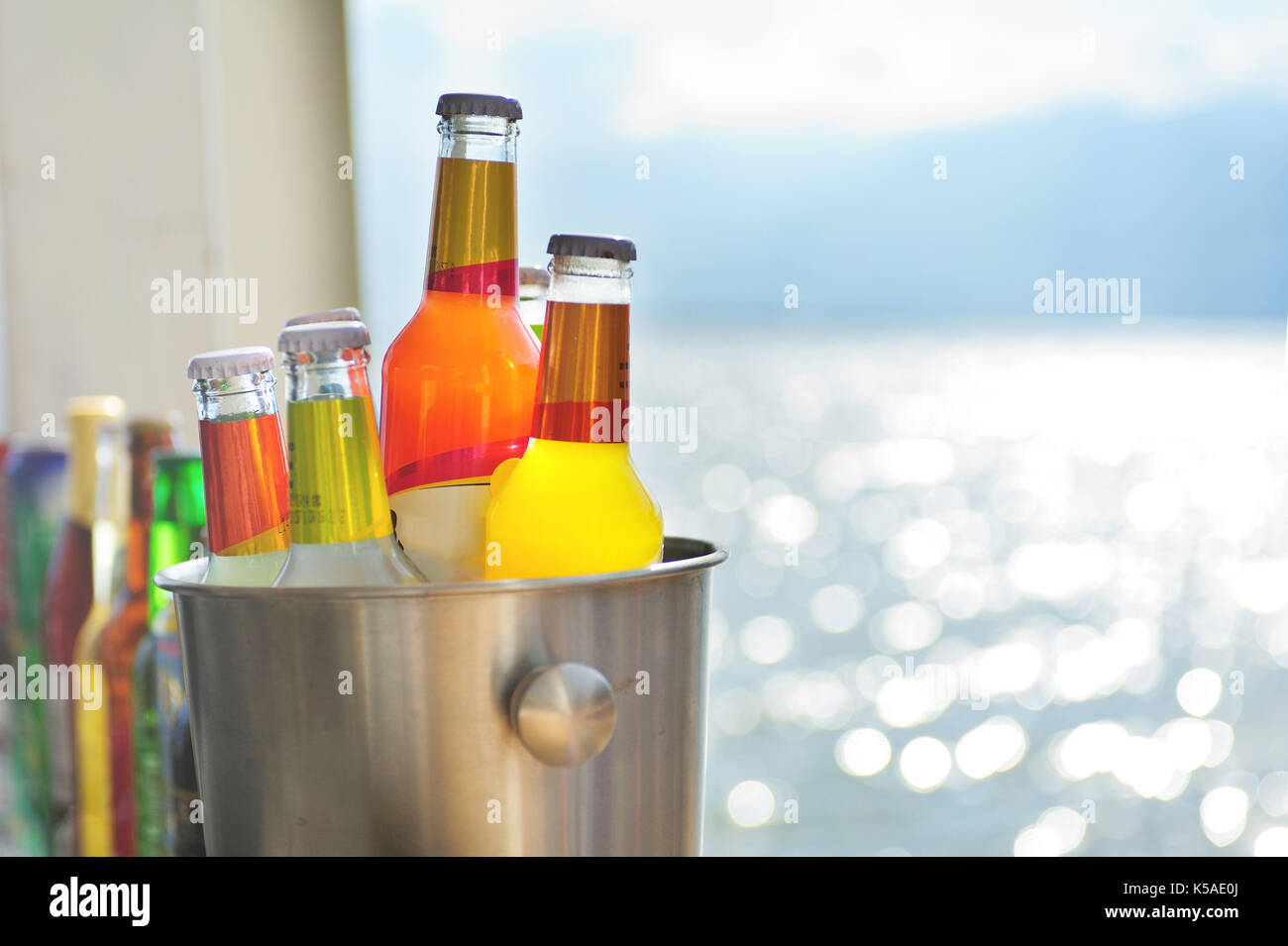 Bouteilles colorées placées sur le bureau à côté du lac. Banque D'Images