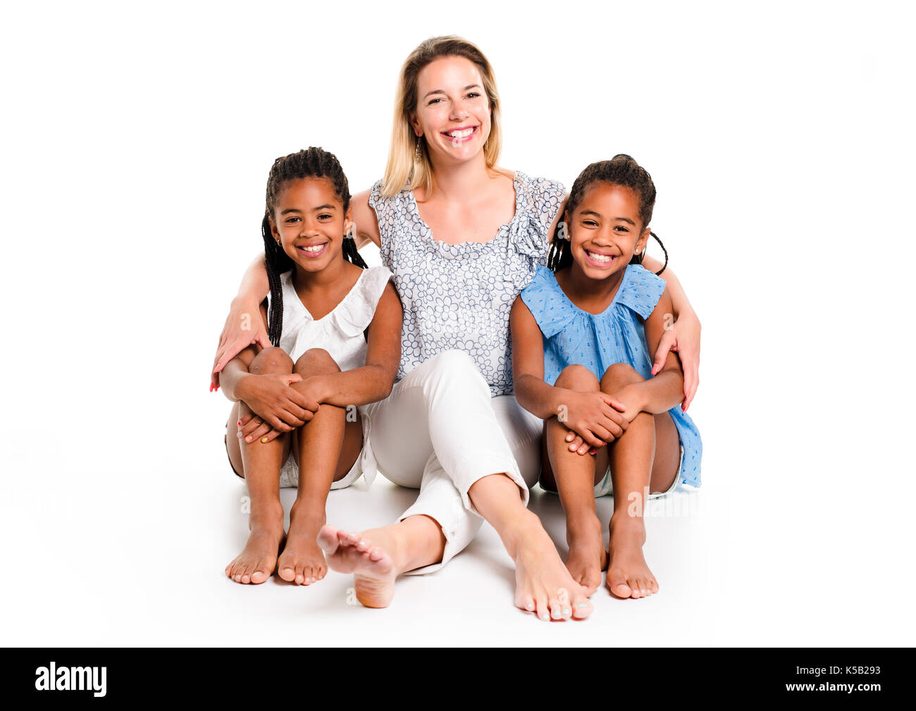 Deux lits jumeaux afro enfant posant sur un fond blanc studio avec mère blanc Banque D'Images