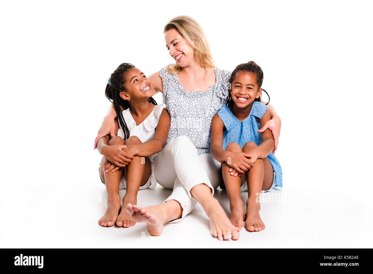 Lits jumeaux afro enfant posant sur un fond blanc studio avec mère blanc Banque D'Images