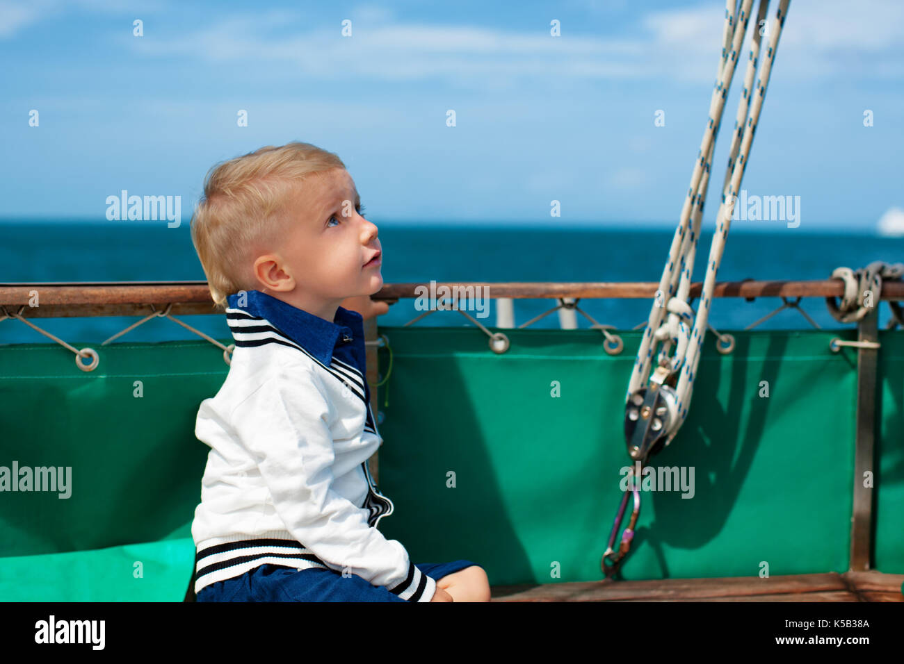 Jeune capitaine joyeux portrait. Heureux l'enfant sur le pont du yacht à voile, ont plaisir à découvrir les îles, voyages en mer tropicale sur croisière d'été. Banque D'Images