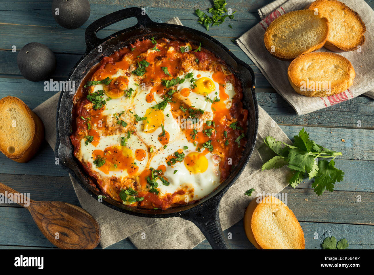 Shakshuka saucy fait maison avec des oeufs coriandre et tomates Banque D'Images