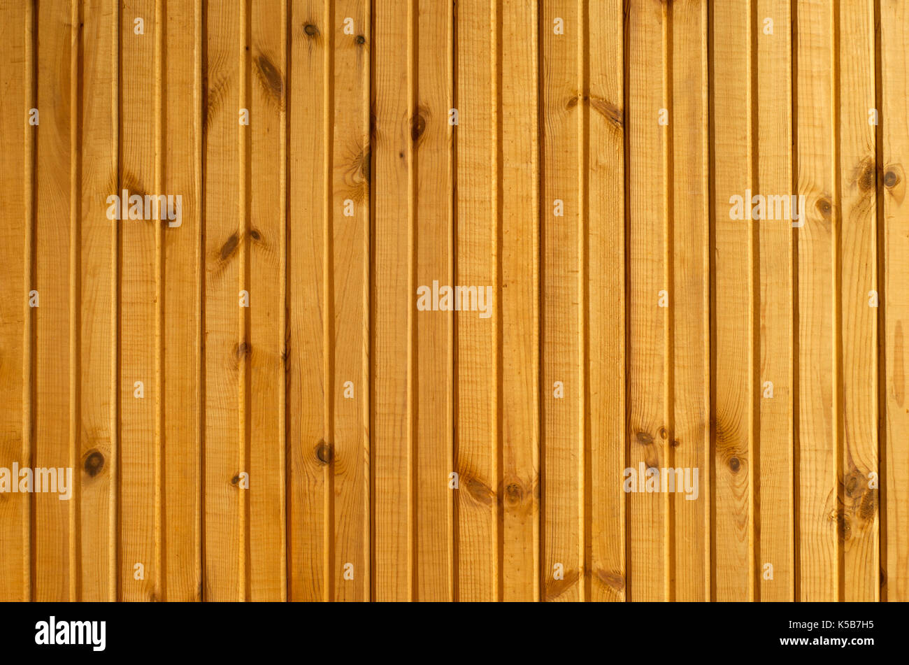 Contexte : une section du mur bordée de lamelles en bois laqué jaune Banque D'Images