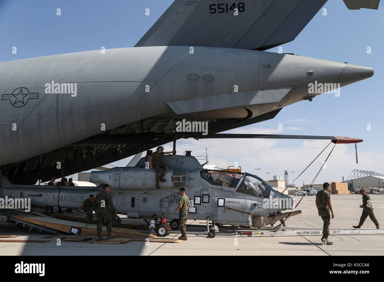 Les Marines américains avec l'Escadron d'hélicoptères d'attaque légère Marine 367 (HMLA-367) décharger un AH-1W Super Cobra d'un C-17 Globemaster III Banque D'Images