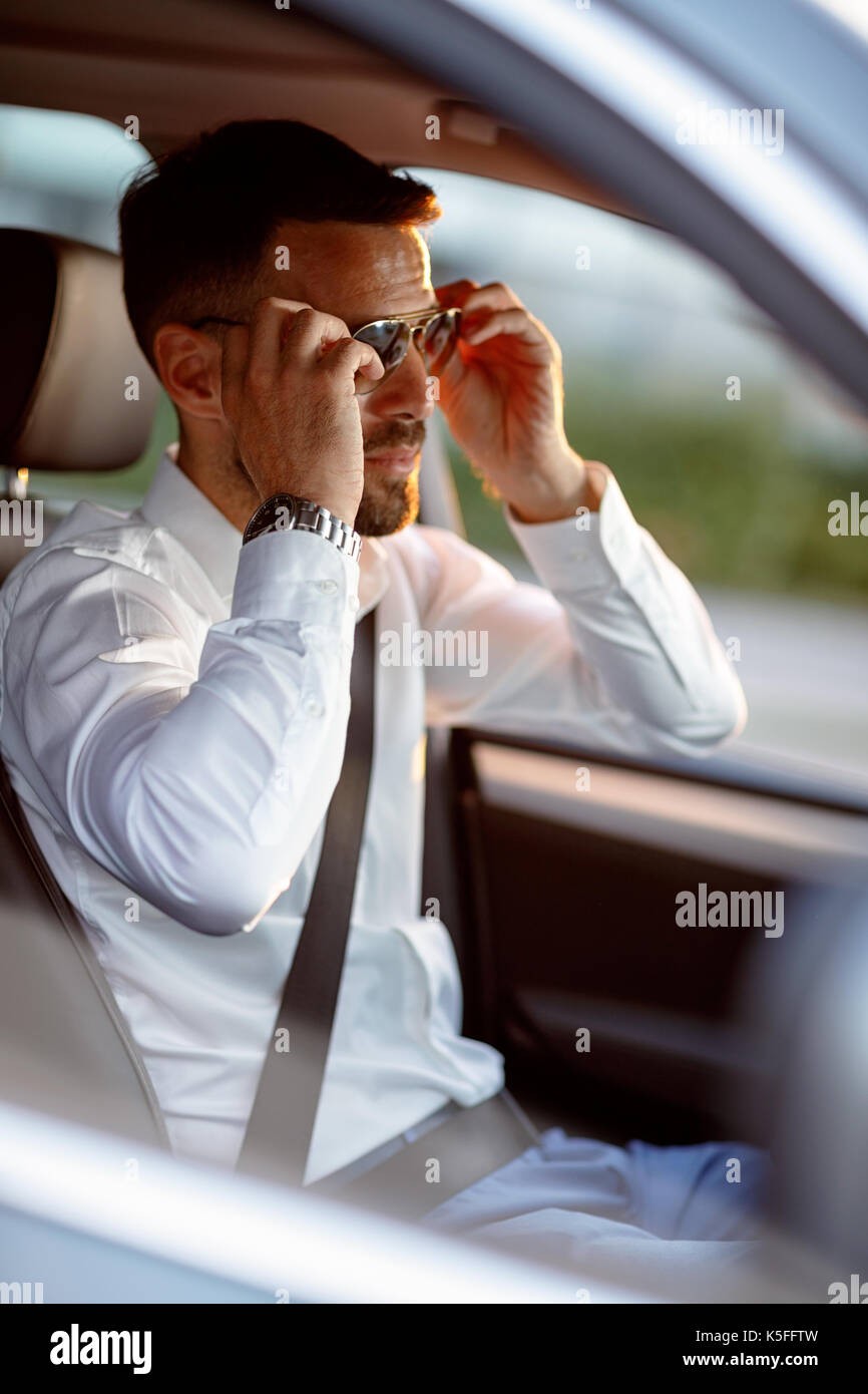 Handsome man driving car le port de lunettes de soleil Banque D'Images