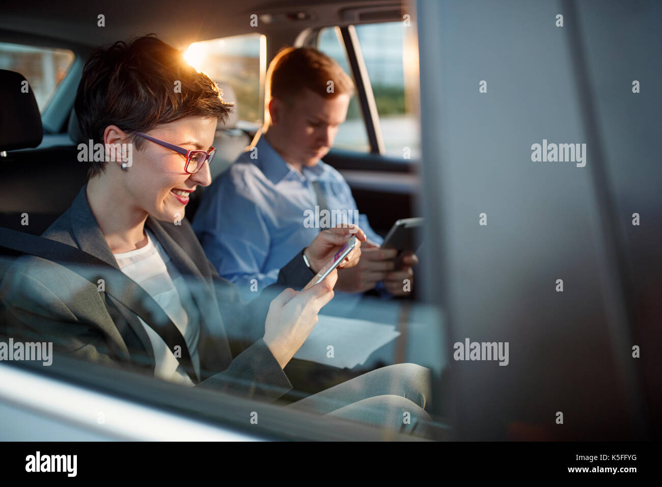 Smiling business woman en appelant le numéro de téléphone intelligent driving car Banque D'Images