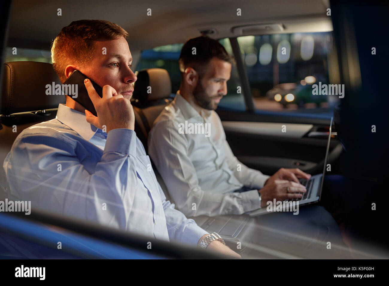 Nuit de travail- l'homme d'affaires fatigué smartphone utiliser dans la voiture Banque D'Images