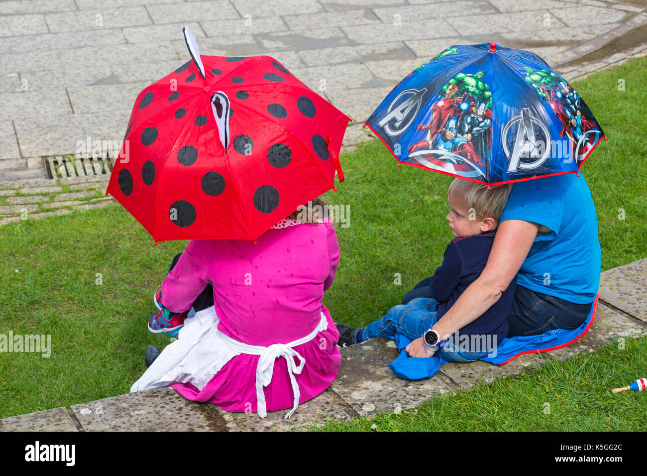 Swanage, Dorset, UK. Sep 9, 2017. Météo France : forte pluie et tonnerre à Swanage. Des gens assis sur mur sous les parasols en essayant de garder au sec. Credit : Carolyn Jenkins/Alamy Live News Banque D'Images