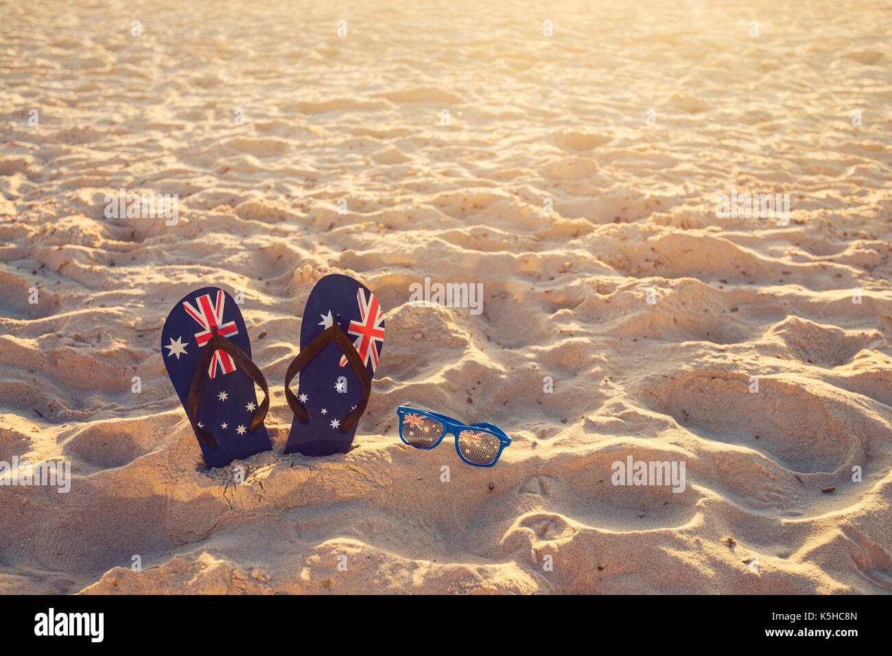 Tongs et lunettes de soleil dans le sable sur une plage, de l'Australie jour concept Banque D'Images