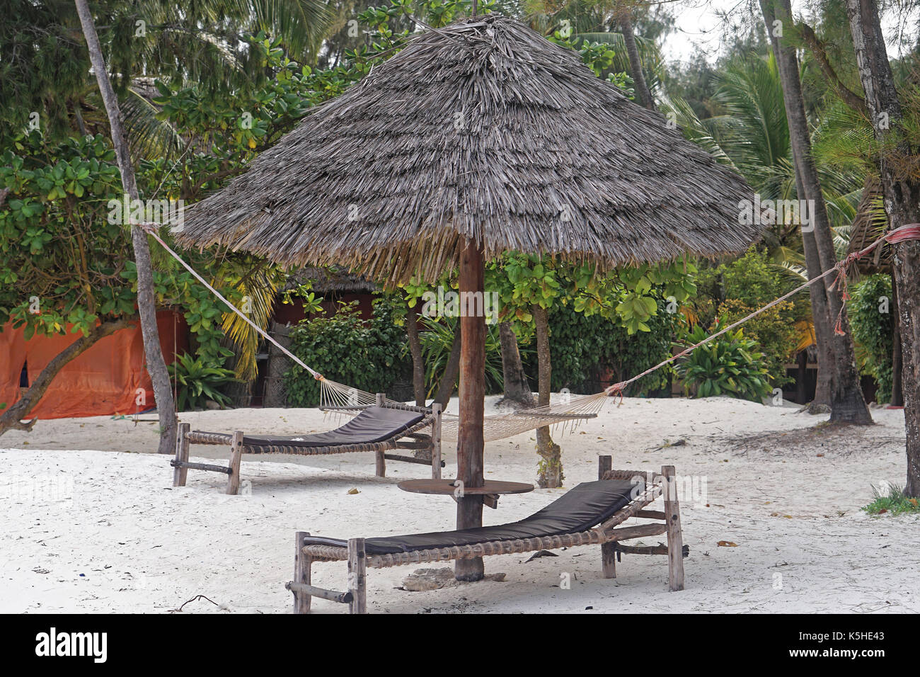 Lit de plage parasol sur palm sous le sable blanc Banque D'Images